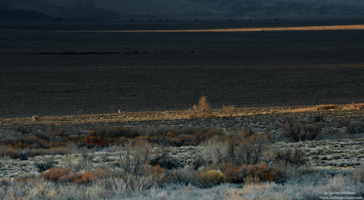 &nbsp;Late light creeps through gaps in the Sierra peaks, leaving shadows and light on the Owens Valley floor.