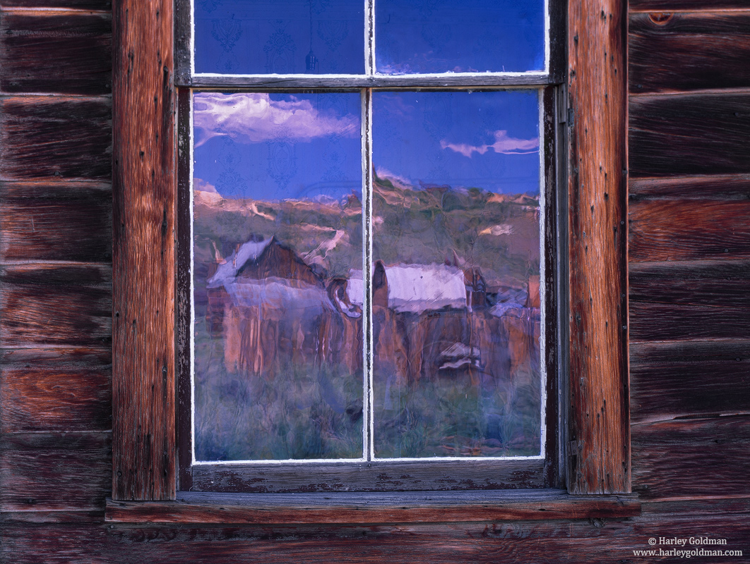 Reflections in the antique window glass of an abandoned house resemble a watercolor painting.